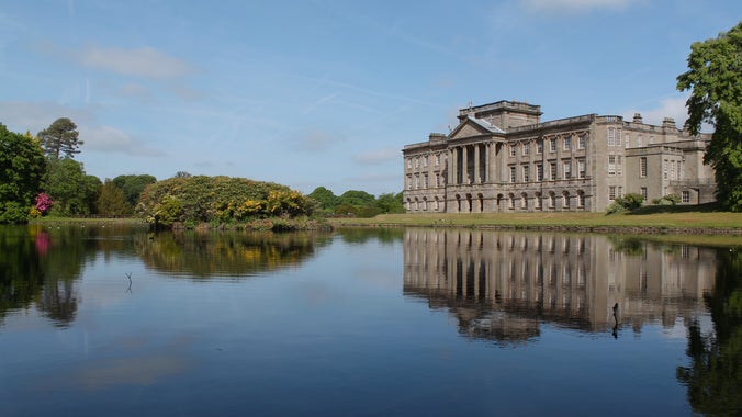 The South front of Lyme, Cheshire seen from across the reflecting lake on a sunny summer's day.